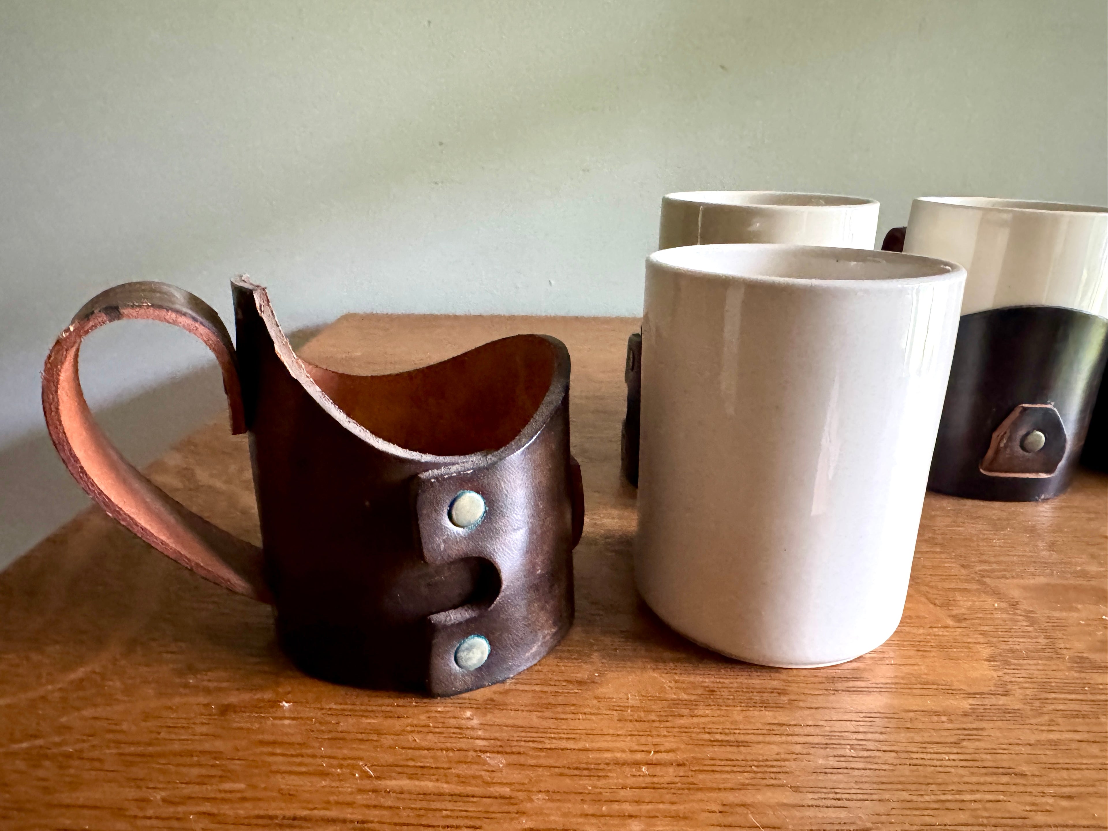 Set of 4 Tooled Leather Mug Holders with Handles and White Ceramic Cups